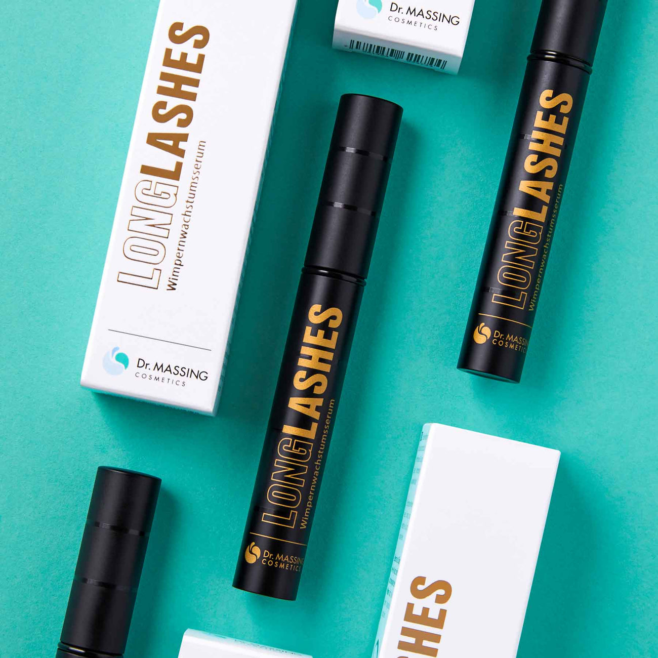 Dr. Massing LongLashes Wimpernserum Serum für lange Wimpern Fläschchen mit Verpackung auf petrolfarbigen Hintergrund